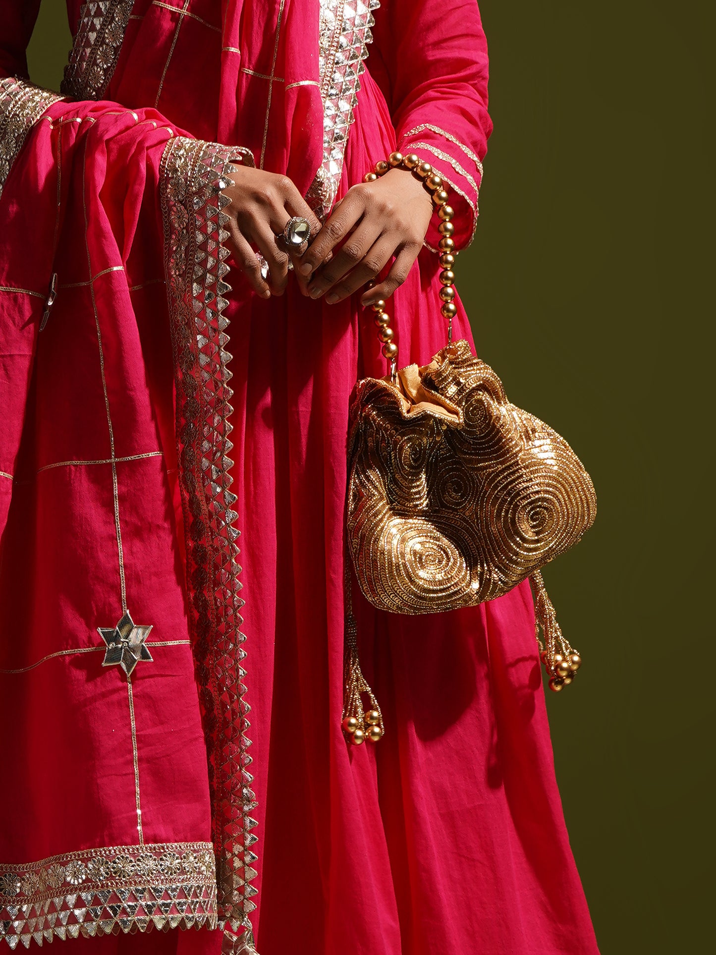 Antique gold matka potli bag by aclutchstory with intricate design, seen on Anjum Fakih, showcasing traditional craftsmanship.