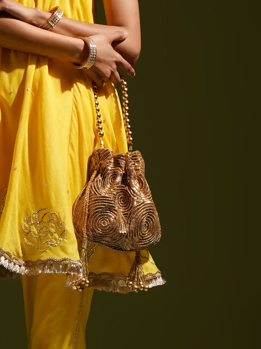 Antique gold matka potli bag by aclutchstory, featuring intricate design, seen on Anjum Fakih, perfect for traditional occasions.