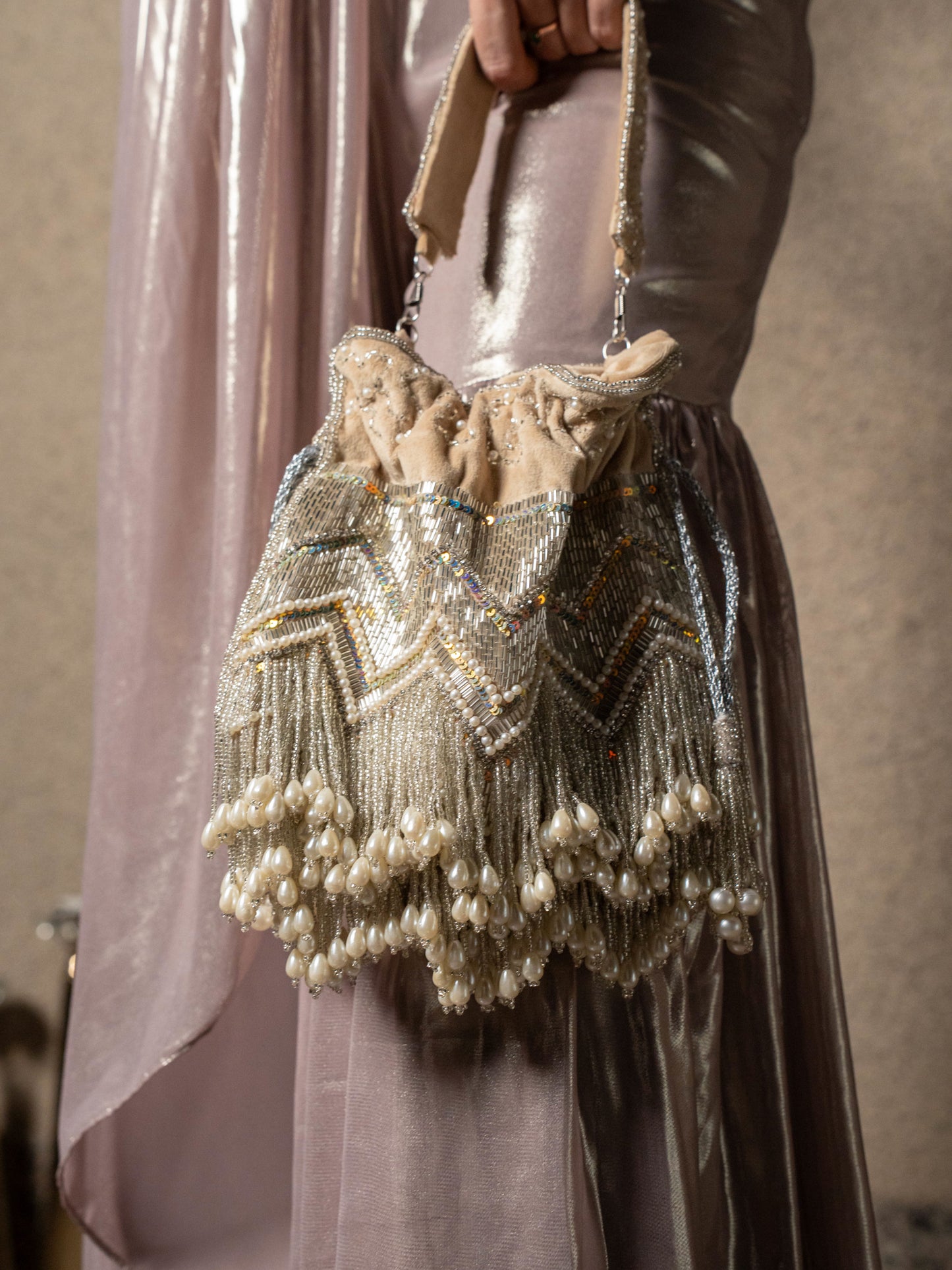 Beige pearl tassels potli bag with intricate embroidery, traditional Indian clutch for special occasions, by aclutchstory.