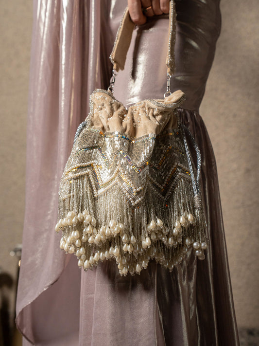 Beige pearl tassels potli bag with intricate embroidery, traditional Indian clutch for special occasions, by aclutchstory.