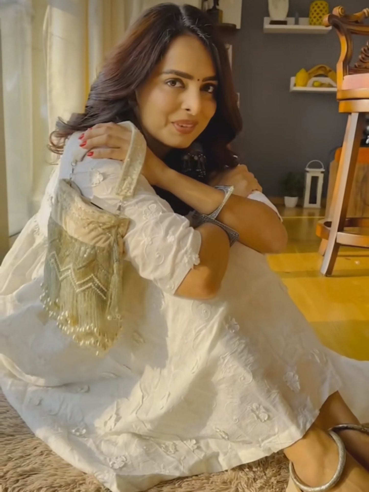 Beige pearl tassels potli bag with intricate embroidery and drawstring closure, featuring elegant traditional design.