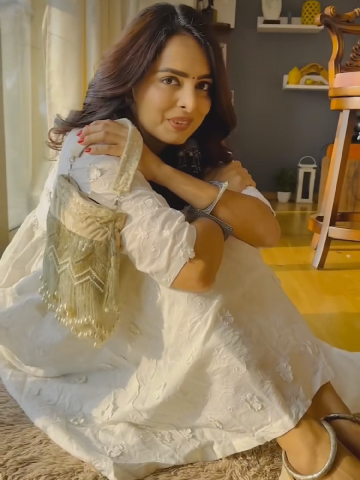 Beige pearl tassels potli bag with intricate embroidery and drawstring closure, featuring elegant traditional design.