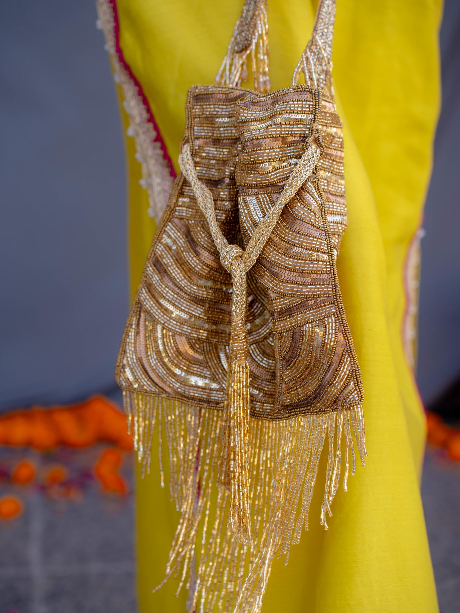 Glittering antique potli bag with tassels by aclutchstory featuring intricate embroidery and traditional Indian design.