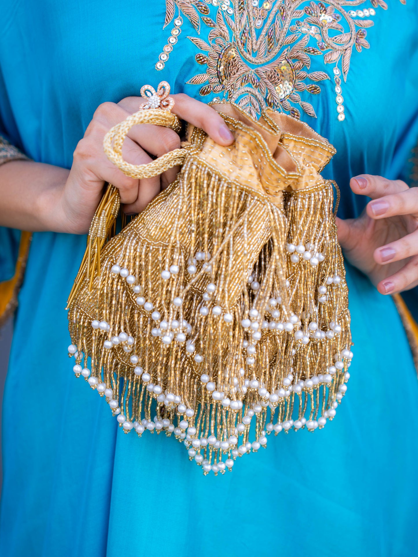 Gold fringe glam potli bag with intricate design, perfect for festive occasions and traditional events.