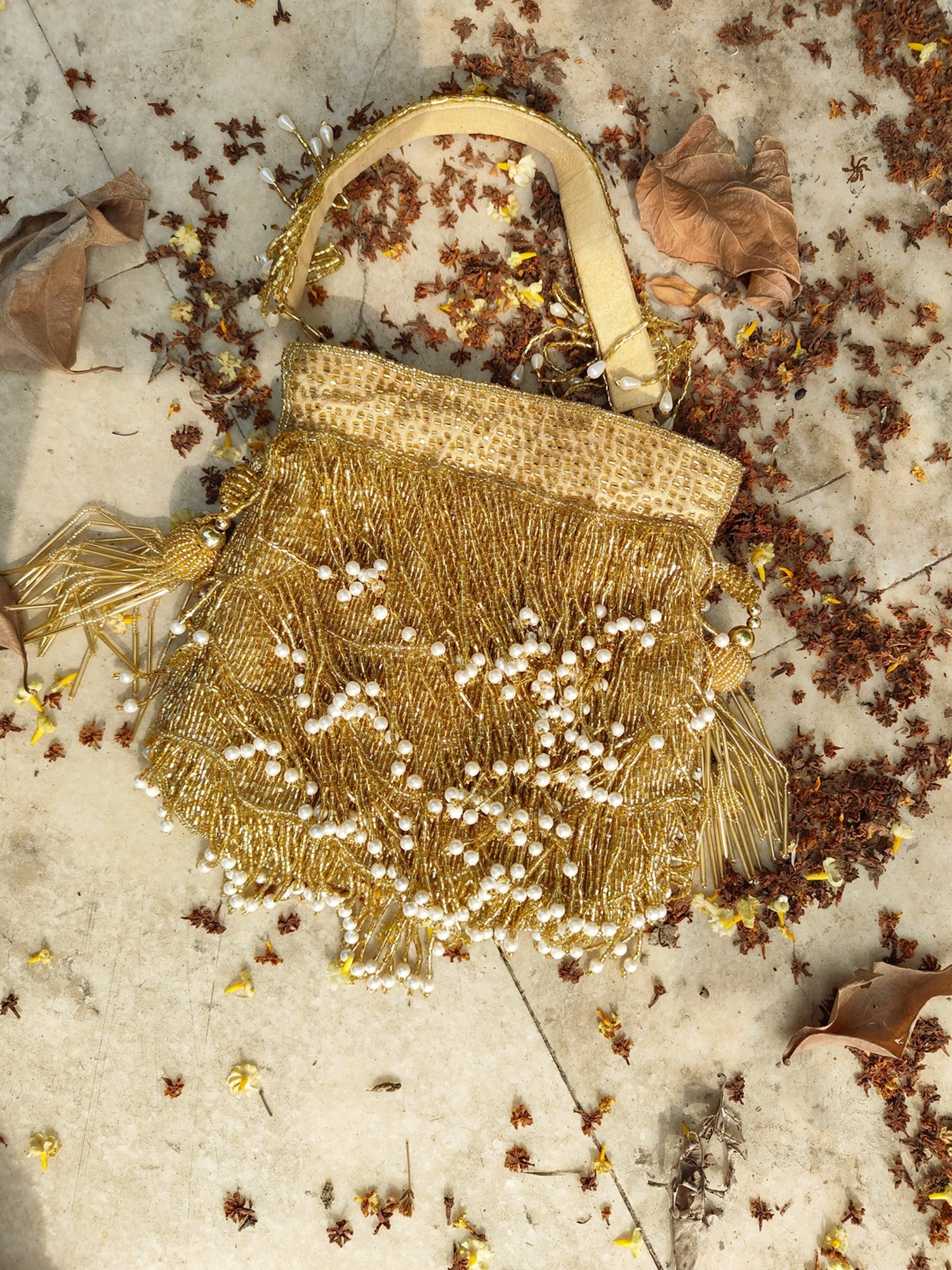 Gold fringe glam potli bag with intricate embroidery, stylish accessory perfect for festive occasions and traditional attire.