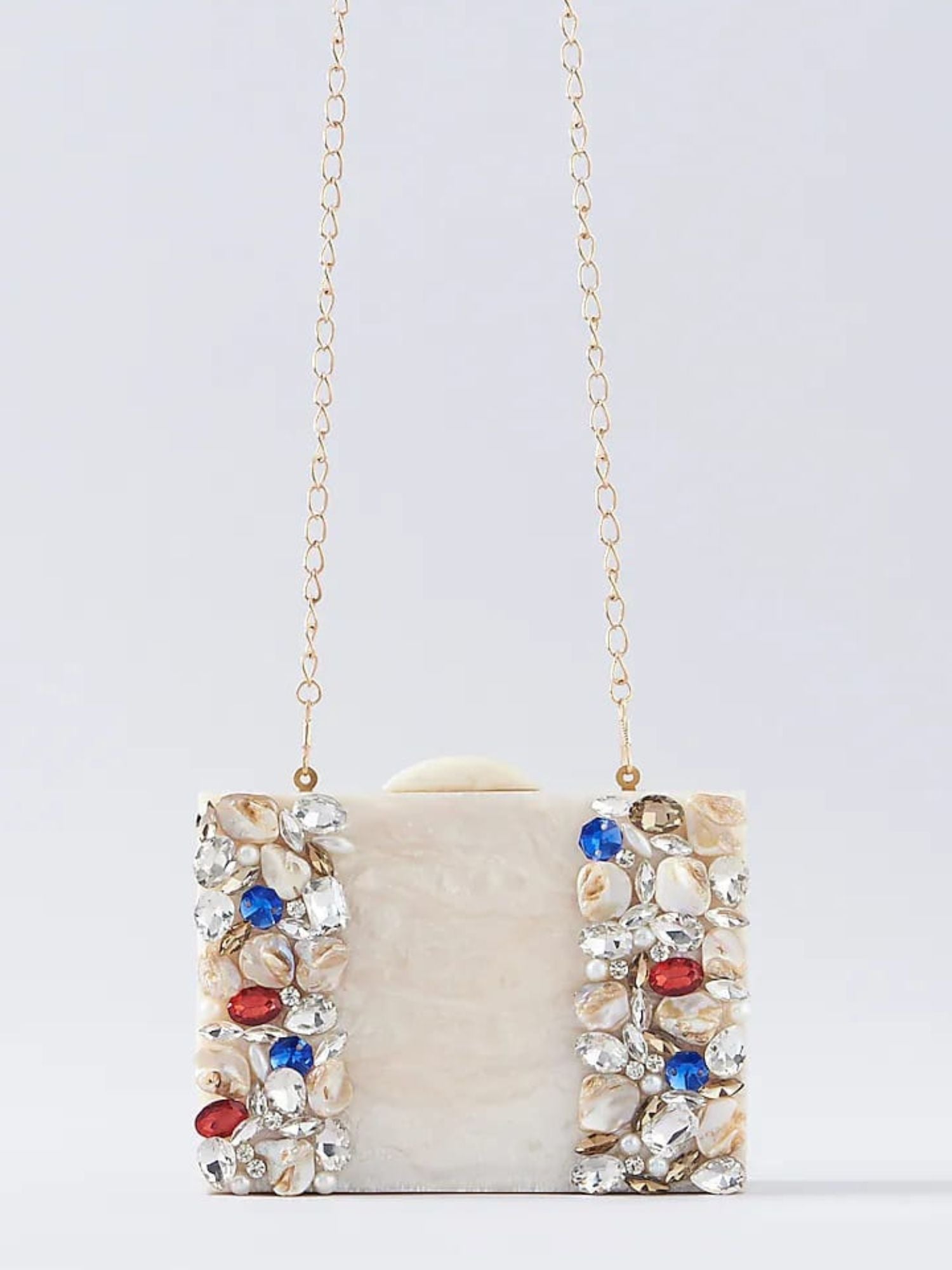 Ivory embellished resin clutch bag with intricate details, featuring a sleek rectangular shape and decorative accents.