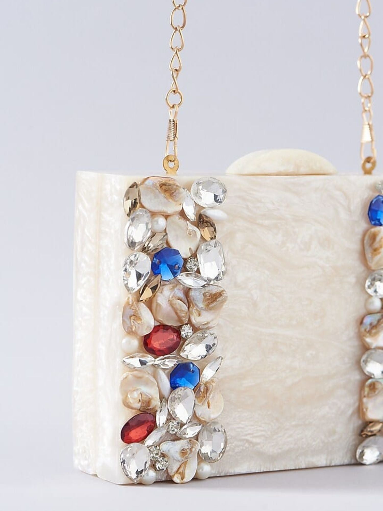 Ivory embellished resin clutch bag with intricate detailing and a sleek rectangular shape, perfect for evening events.