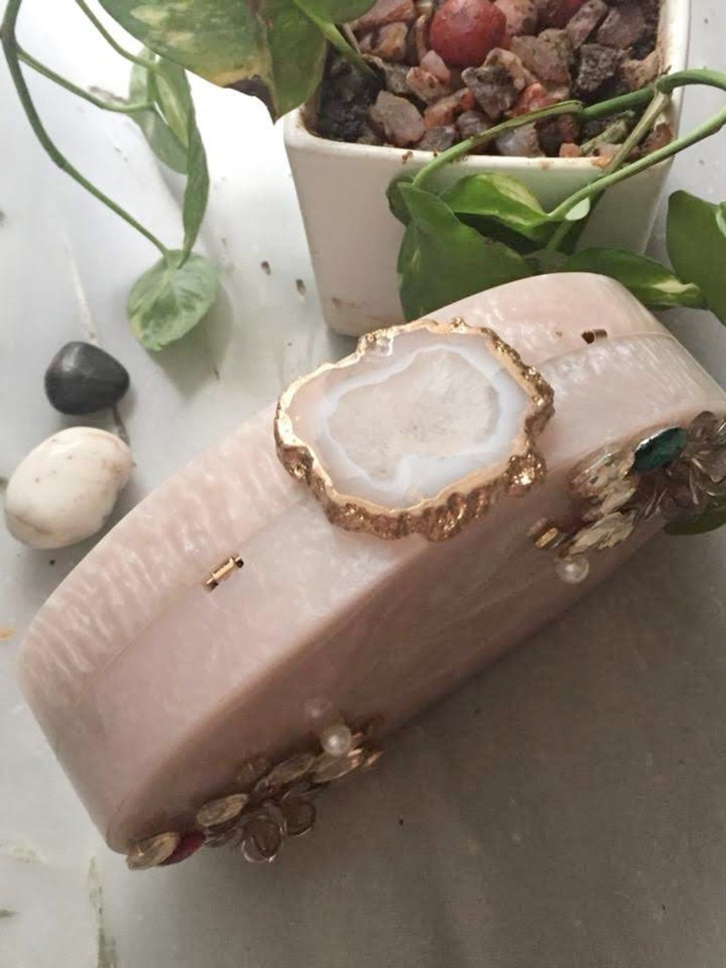 Oval agate resin clutch by aclutchstory featuring a smooth, polished stone surface and elegant design.