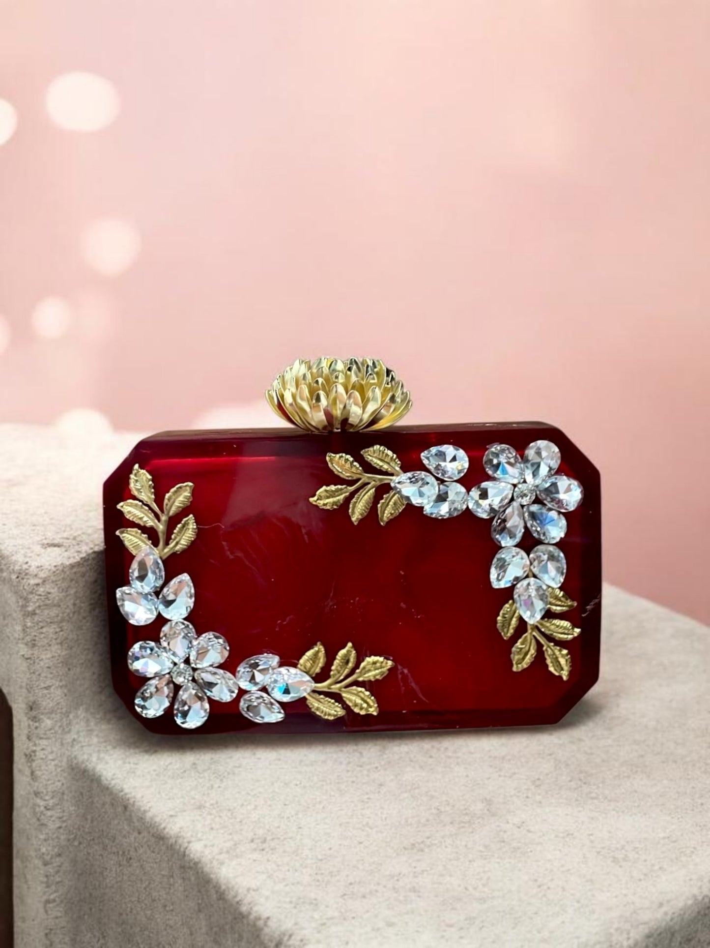 Ruby Aura clutch bag by aclutchstory featuring a vibrant red color with rhinestone work and elegant gold accents.