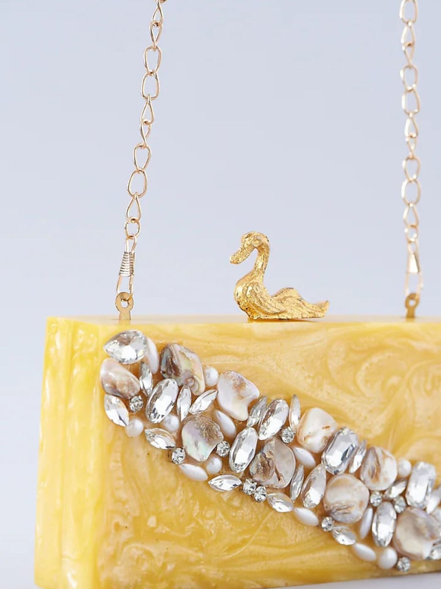 Swan resin clutch purse by aclutchstory featuring a glossy white swan design with gold accents and a textured surface.
