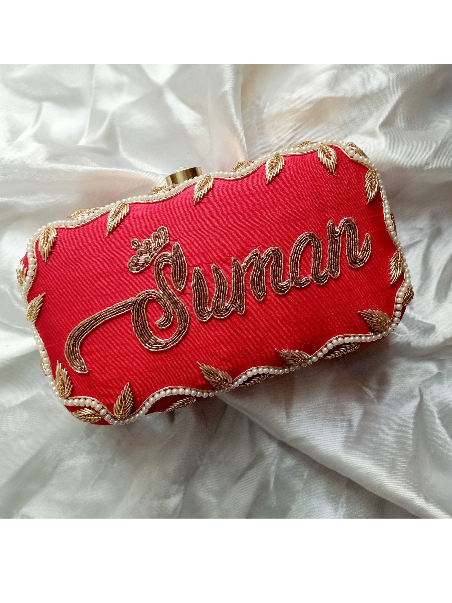 Red Dabka leaf clutch bag with intricate embroidery, custom design by aclutchstory, showcasing detailed craftsmanship and vibrant color.